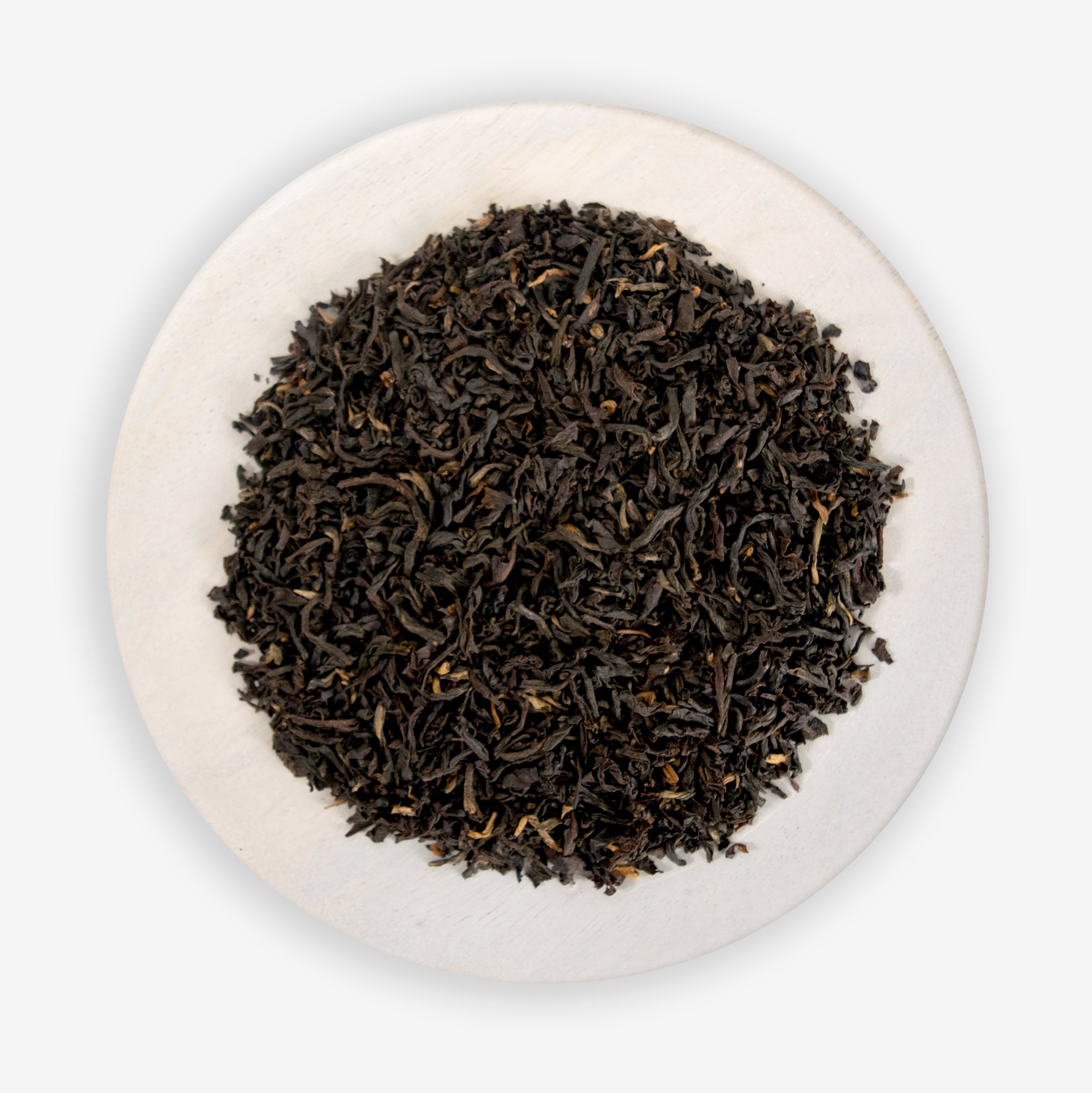 A pile of black tea leaves on a white background.