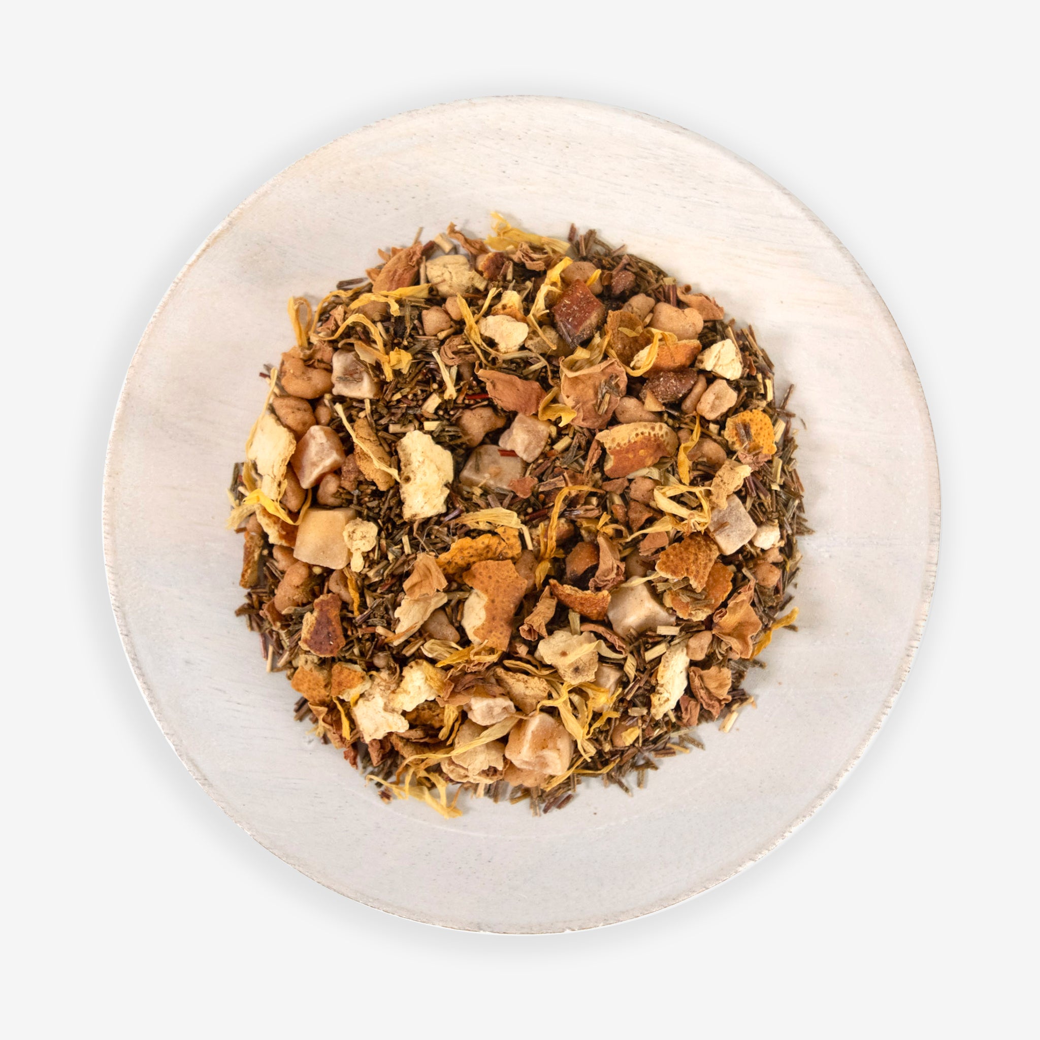 A top view of a plate containing Cape Paradise tea leaves which include a mix of dried fruits and petals.