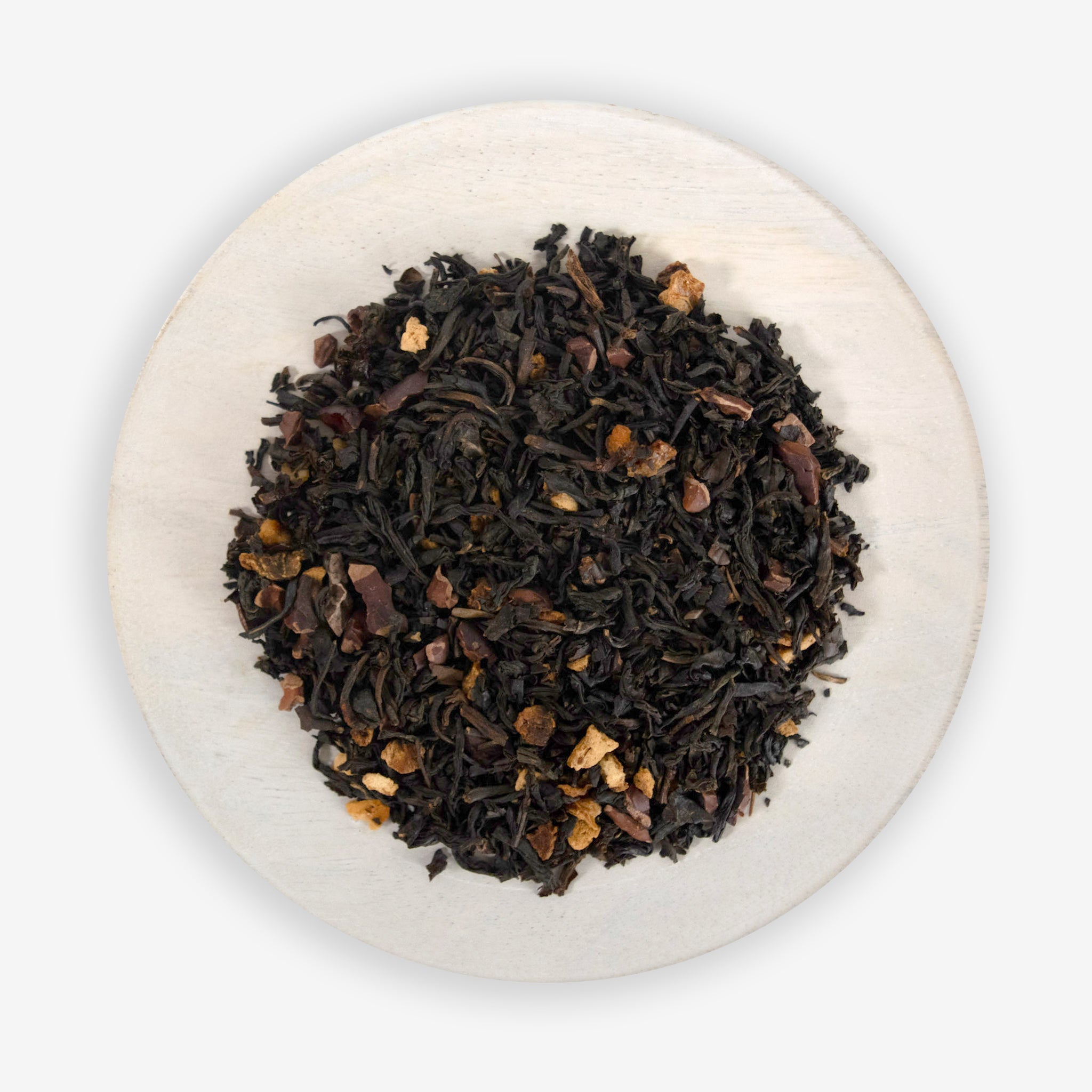 A close-up image of a tea blend containing black tea leaves, cacao nibs, and grapefruit peel, indicative of the product &