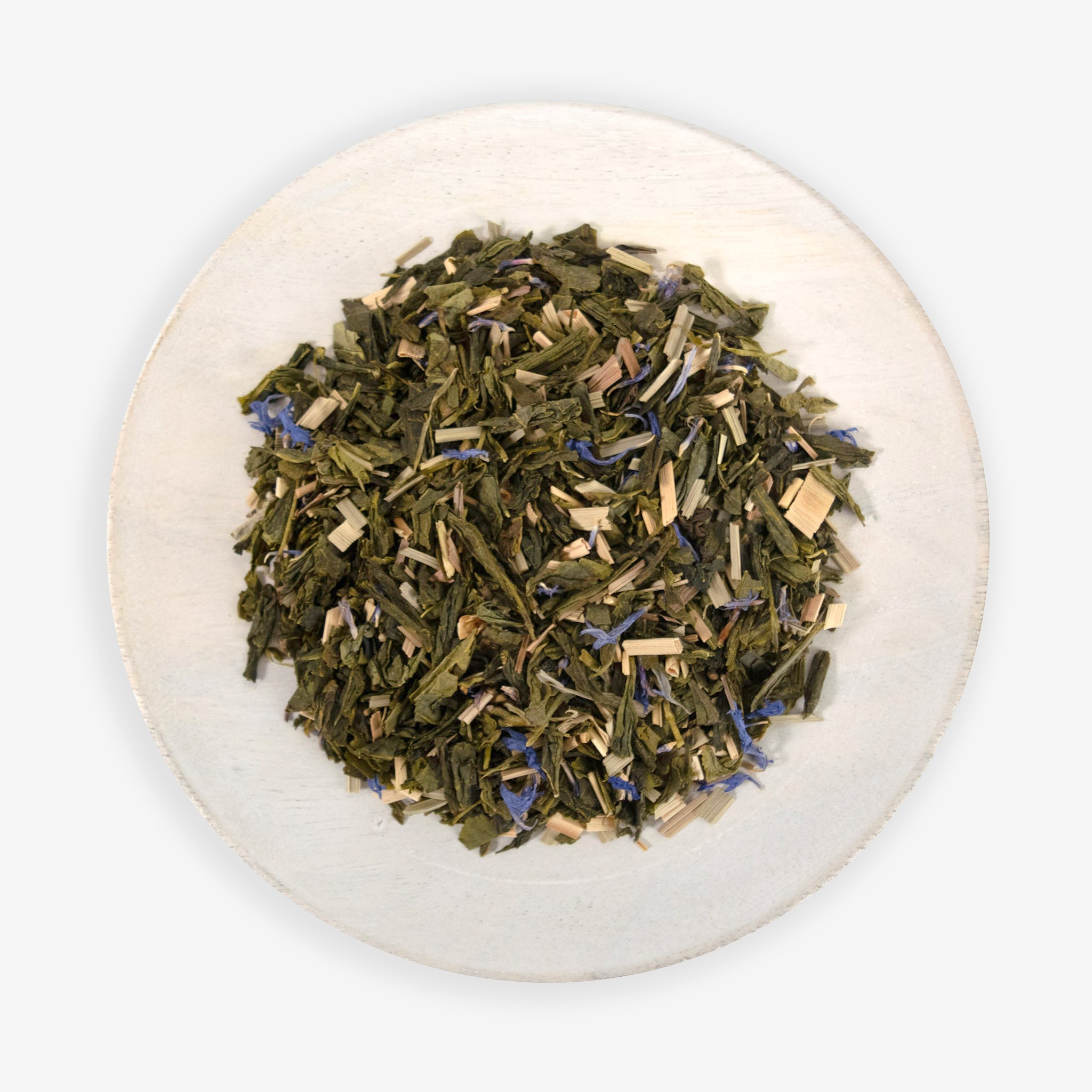 A plate of dried tea leaves, herbs, and blue cornflower petals, which are ingredients for the &