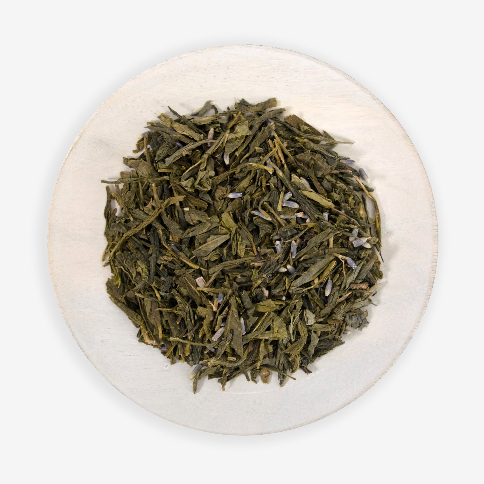 A close-up of dried green tea leaves interspersed with lavender flowers, on a wooden surface.