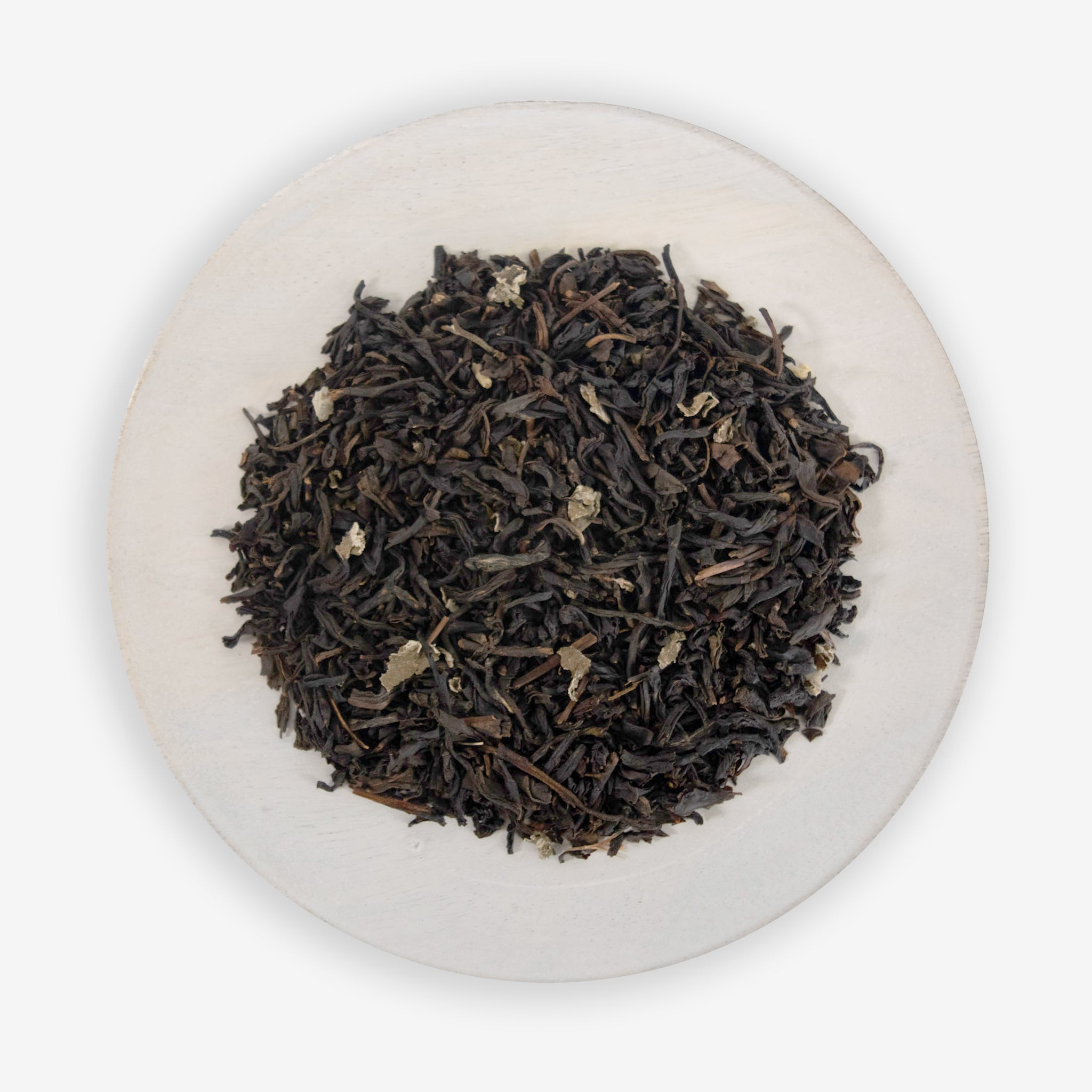 A bowl of black tea leaves with pieces of raspberry visible, indicating a raspberry flavored black tea product.
