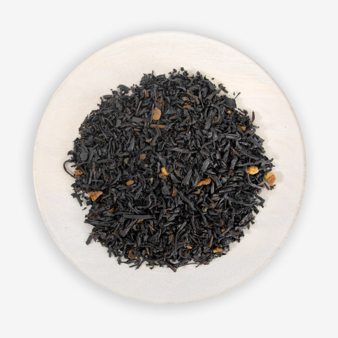 A close-up of black tea leaves mixed with pieces of orange peel and cinnamon.
