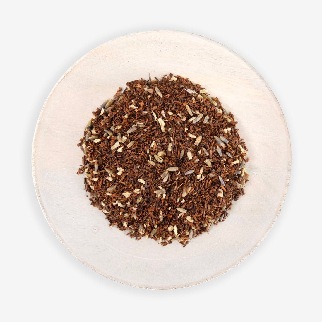 A dish containing loose tea leaves with pieces of lavender and shredded coconut.